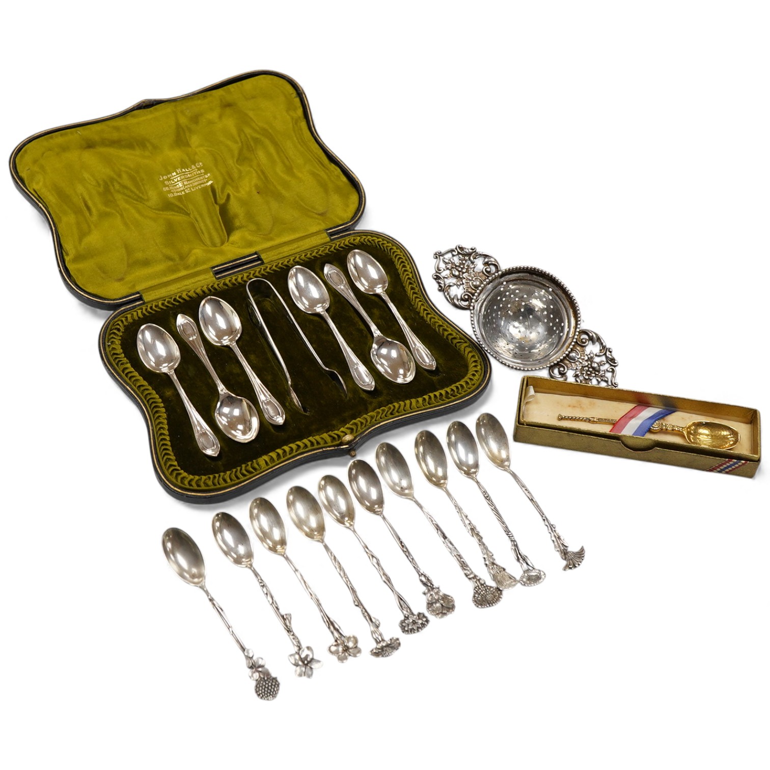 A cased set of six George V silver teaspoons and pair of sugar tongs, by Walker & Hall, Sheffield, 1918, together with a set of ten sterling coffee spoons, with floral terminals, a sterling tea strainer and a boxed Eliza